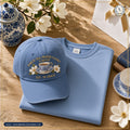 The American Grace Sisterhood Porch Tea Prayer Closet & Besties Embroidered Cap in Soft French Blue paired with matching SW2 Crewneck on warm white oak table
